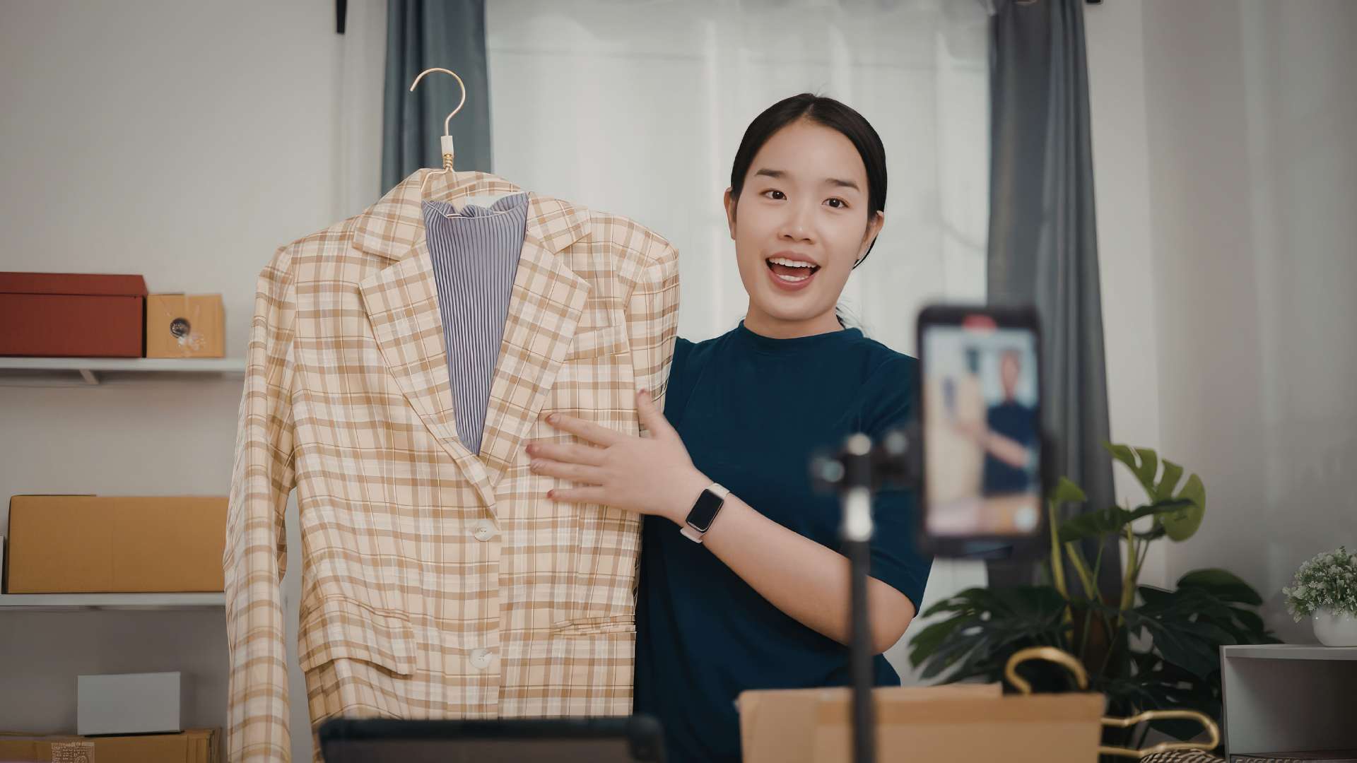 Una ragazza mostra una giacca al telefonino che sta facendo una ripresa